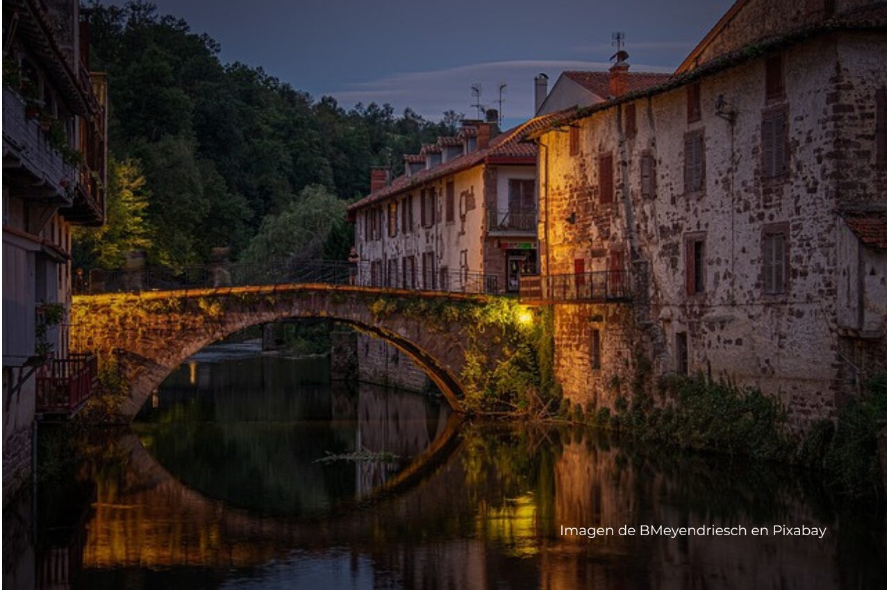 Imagen de un puente y un río en un pueblo antiguo de noche