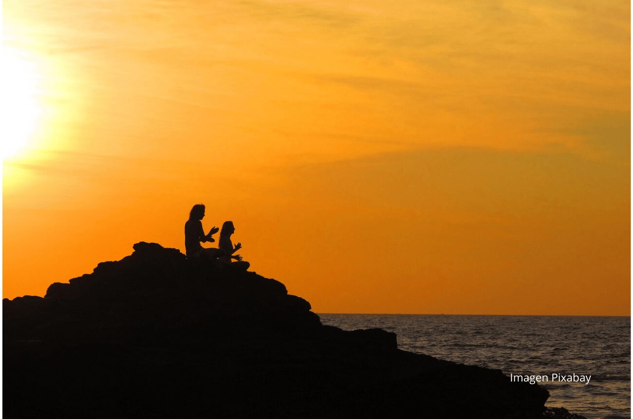 Personas haciendo yoga en un atardecer