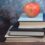 Imagen de libros con manzana roja
