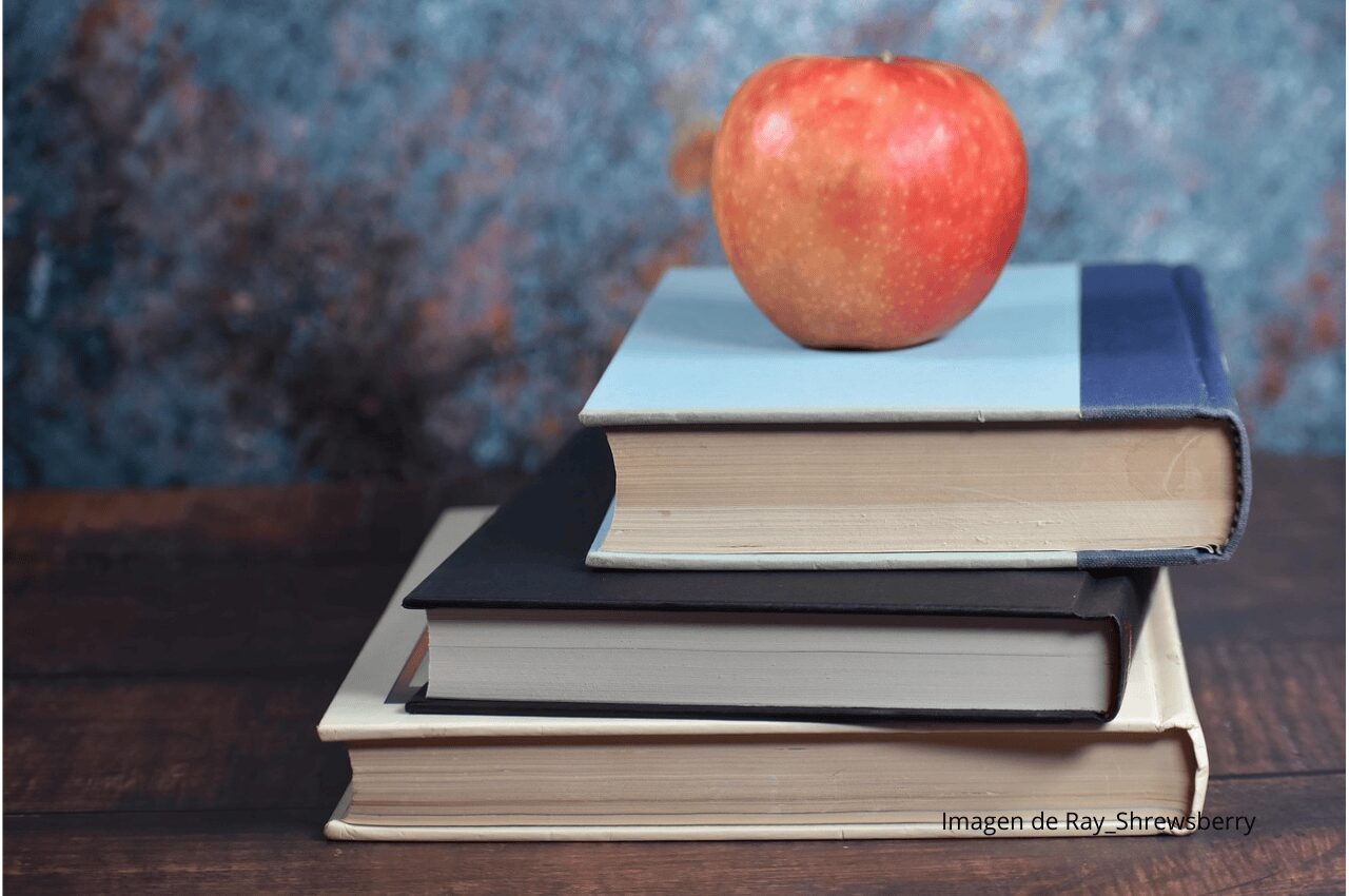 Imagen de libros con manzana roja
