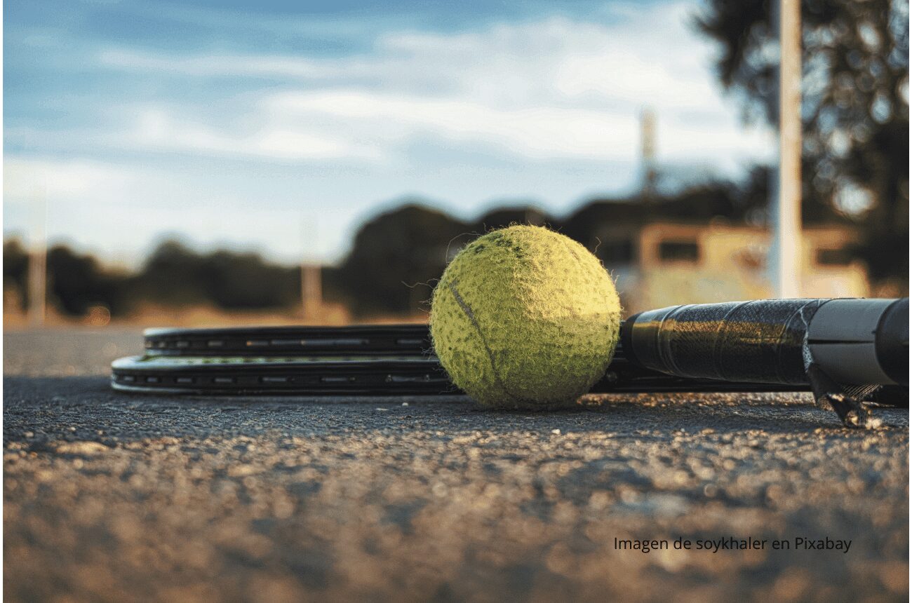 Imagen raqueta y pelota en pista de tenis de tierra batida