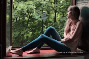 Imagen de una chica mirando por la ventana hacia la naturaleza